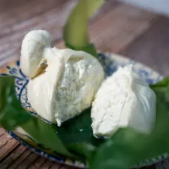 Due burrate fresche su un piatto decorato, un assaggio della loro autentica burrata origine.