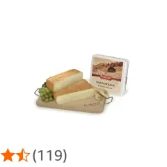 Due fette di formaggio tipo taleggio su tagliere di legno con uva e confezione.