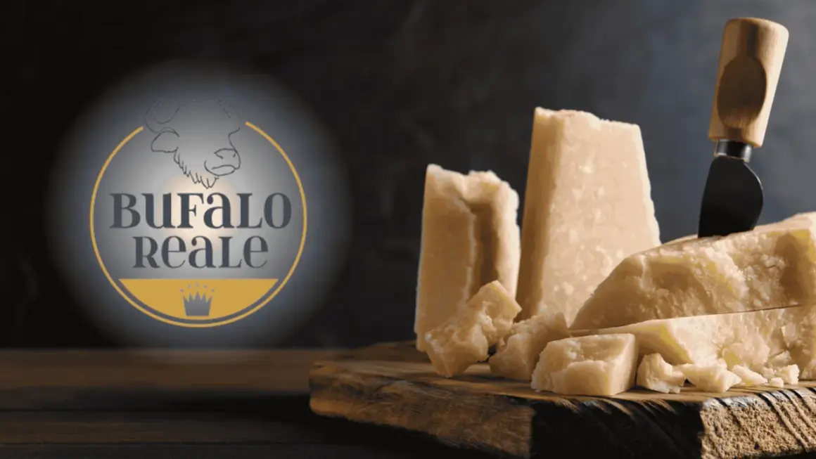 Formaggi stagionati di bufala, con logo "Bufalo Reale". Un coltello da formaggio è conficcato in un pezzo.